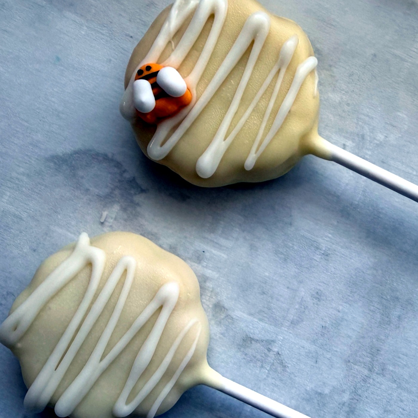 A single white chocolate cake pop with gold sprinkles